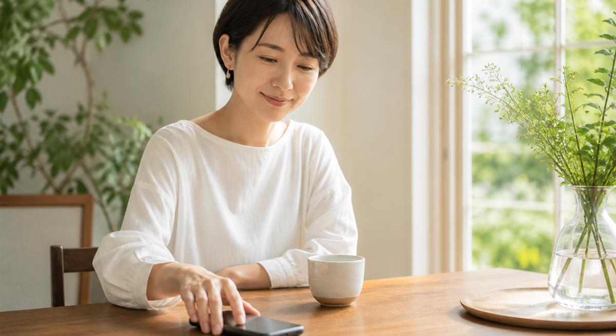 衝動的な連絡を控えてスマートフォンを置く女性