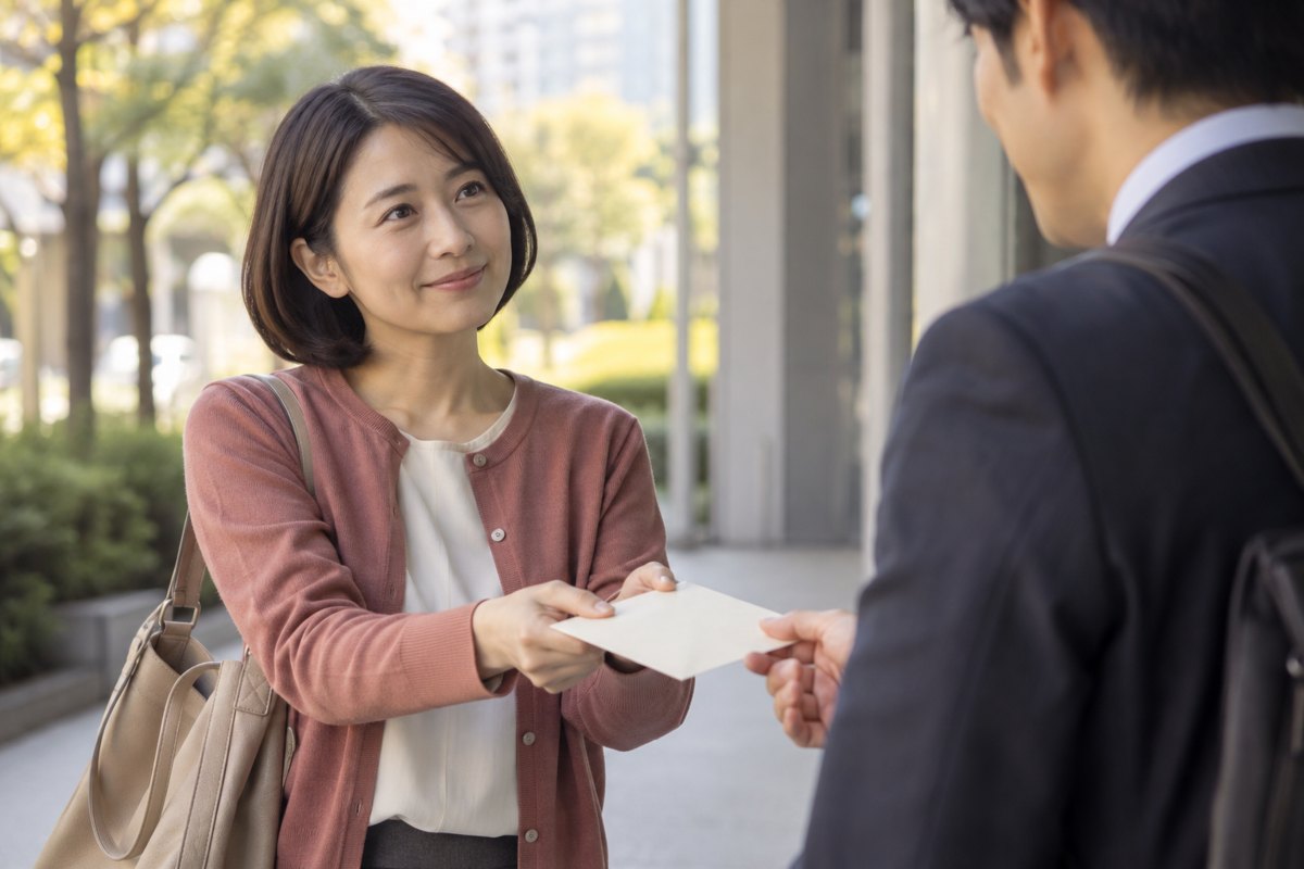 男性へ封筒を渡す女性