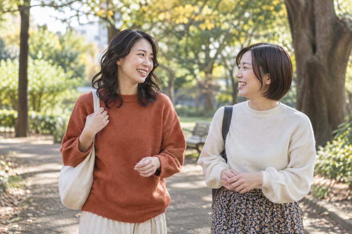 友人と公園を歩く女性