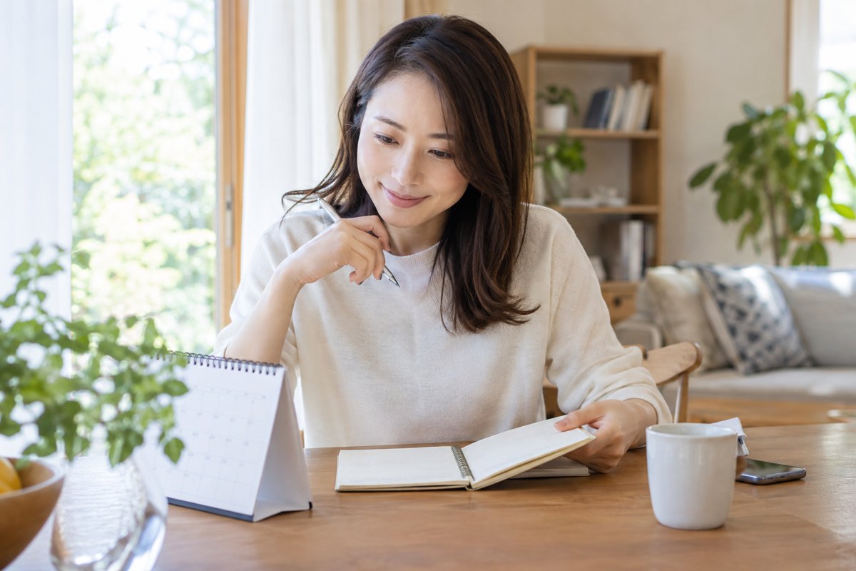 予定をノートで整理する女性