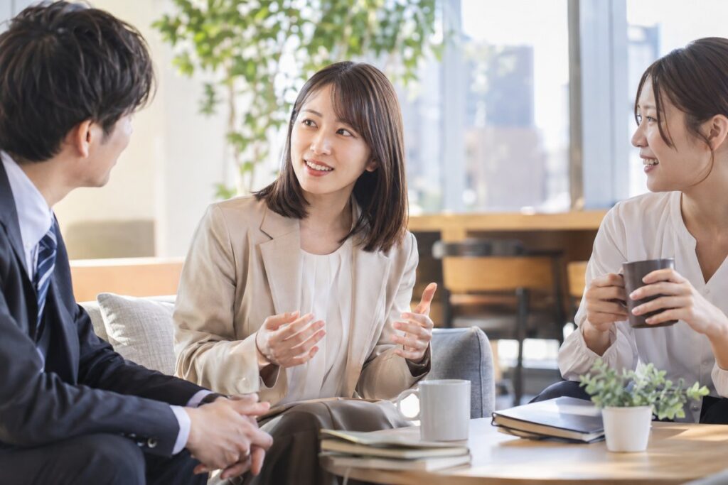 職場の休憩スペースで同僚と話す女性