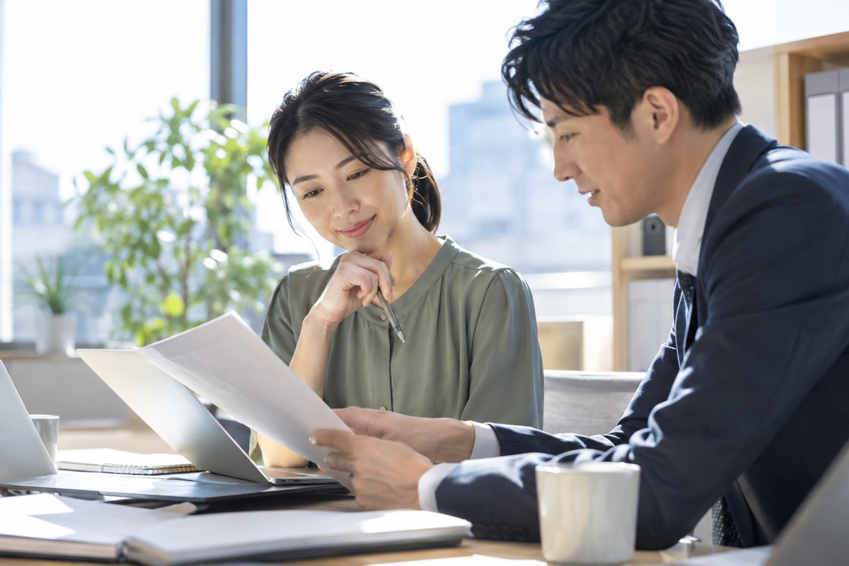 男性の同僚と仕事の資料を確認する女性