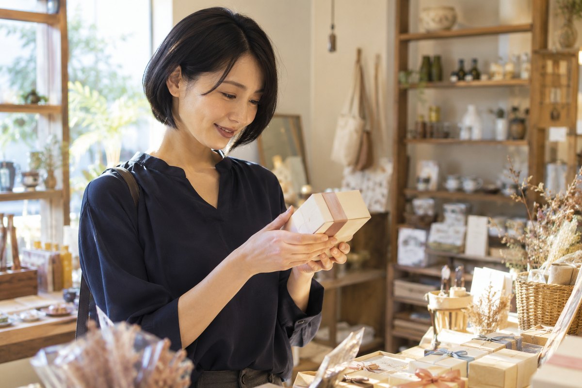 店で小さな贈り物を選ぶ女性