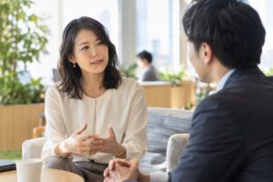 職場で男性の同僚と落ち着いて話す女性