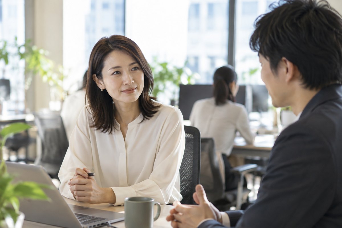 職場で距離を保ちながら話す女性
